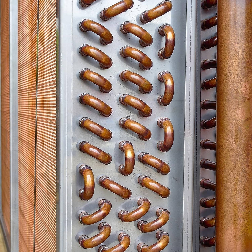 Copper elbow pipe fittings arranged in rows on a perforated panel