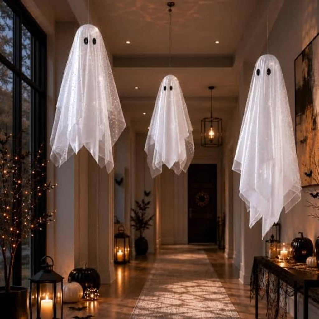 Set of three white hanging ghost decorations with black eyes, sheer veil, and glowing dots