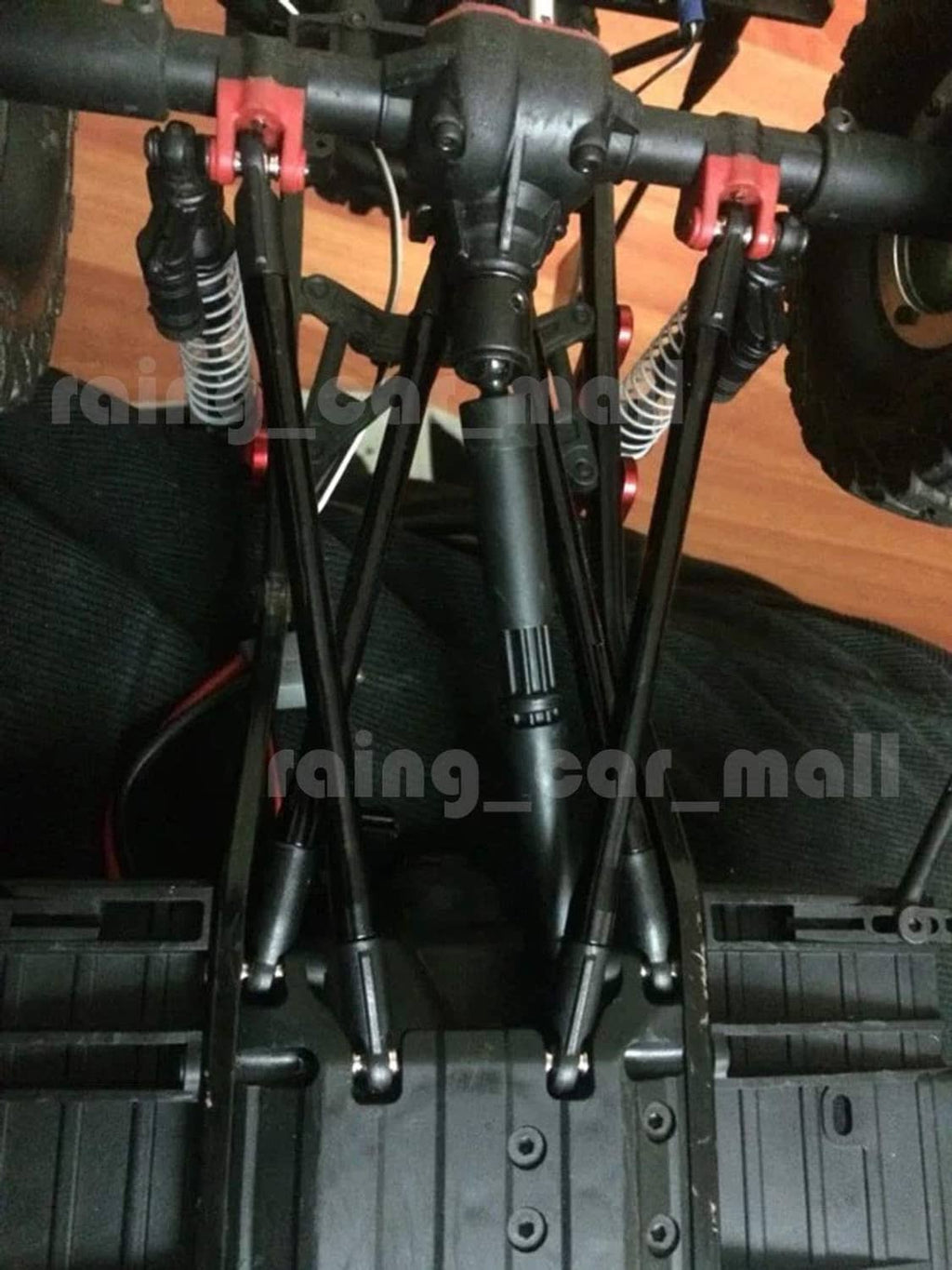 Black rod linkages mounted on an RC truck chassis, front suspension view