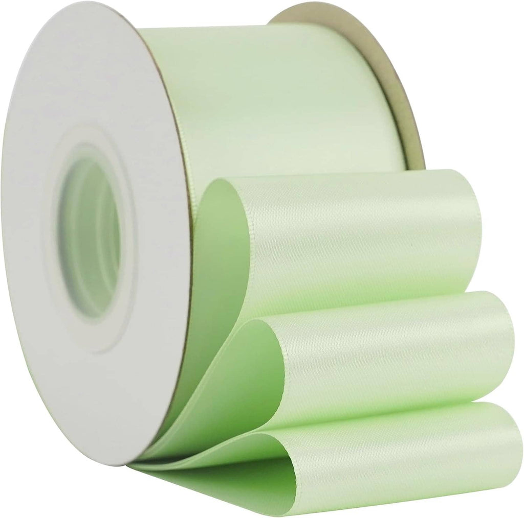 Seafoam green satin ribbon spool with smooth double-faced ribbon rolled into layers.