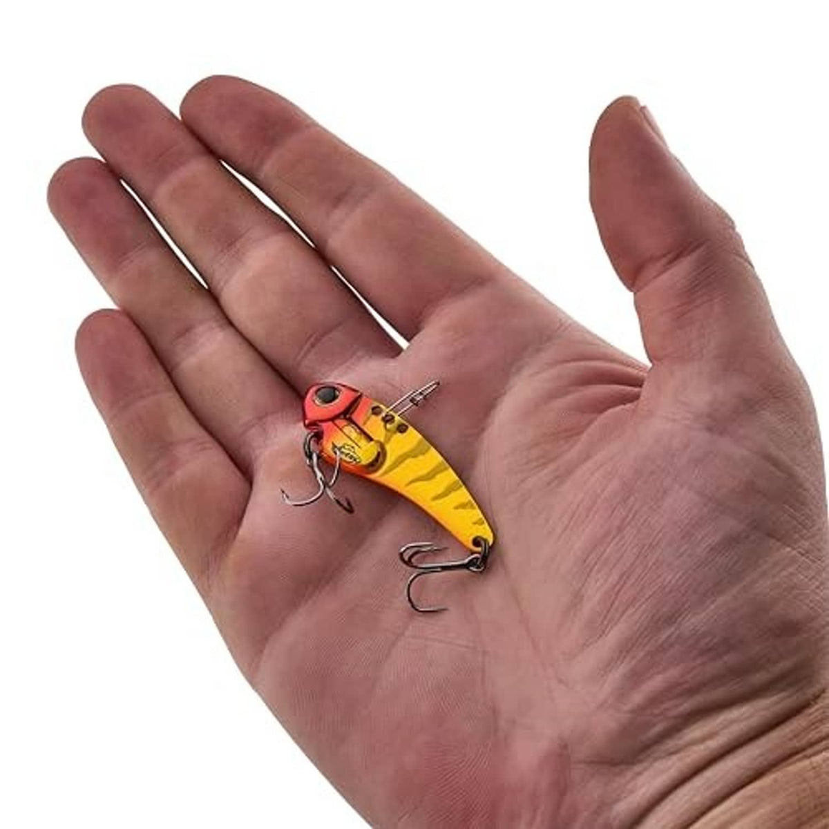 Yellow and red blade fishing lure held in a hand with treble hooks
