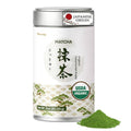 Japanese matcha powder tin with silver lid, green powder heap, and USDA Organic badge