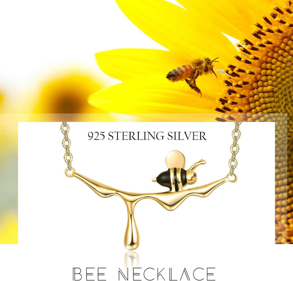 Gold-tone bee pendant necklace featuring black enamel and a fine linked chain