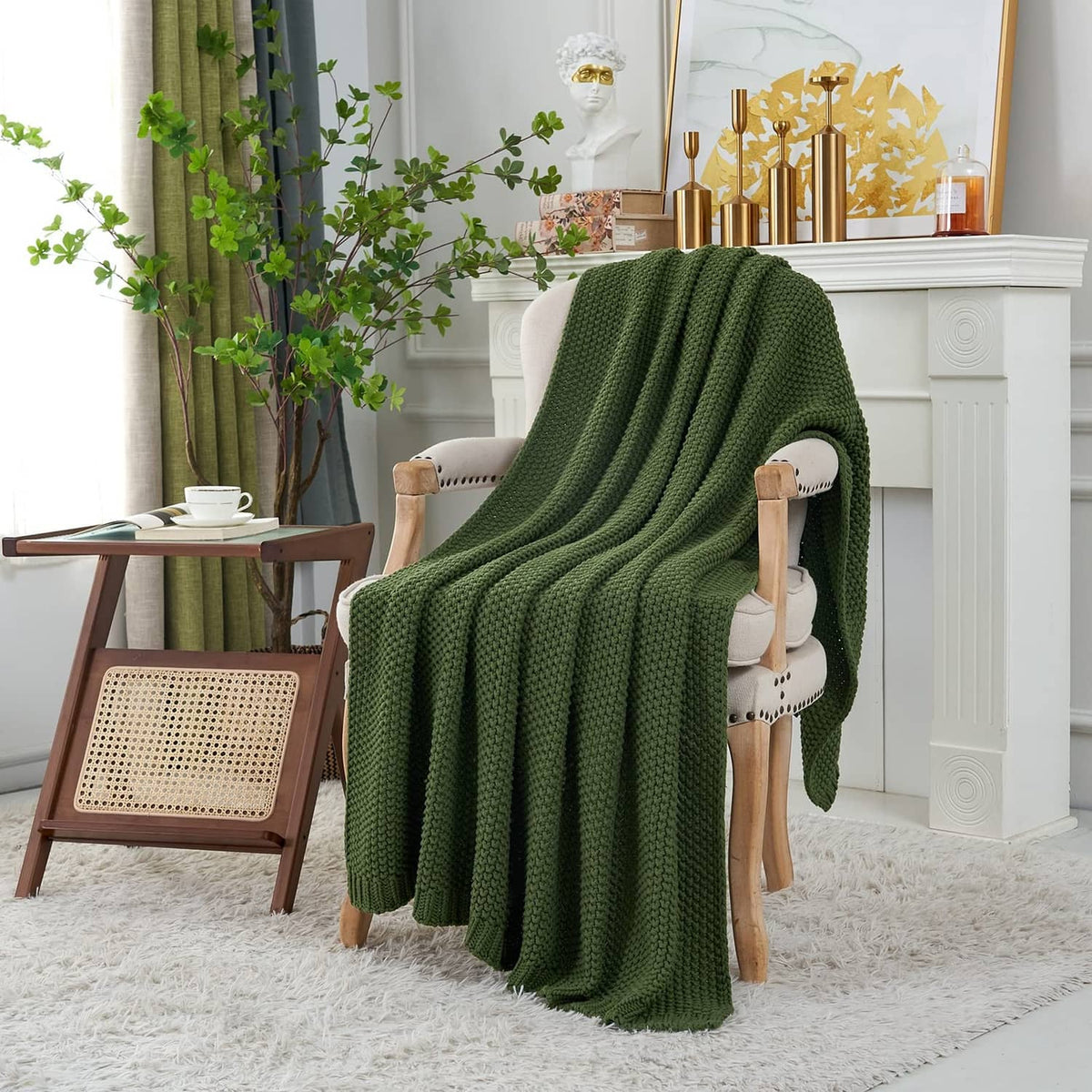 Olive green chunky cable knit throw blanket draped over a chair