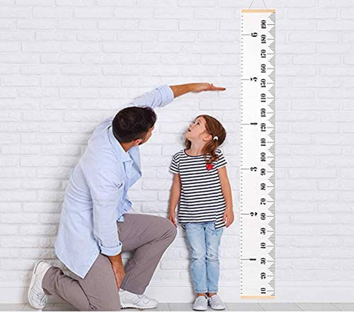 Kids height chart height ruler standing against wall with inch and cm markings.