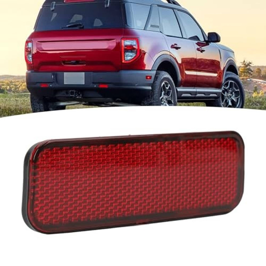 Red rear bumper reflector with rounded rectangular shape and black mounting edge