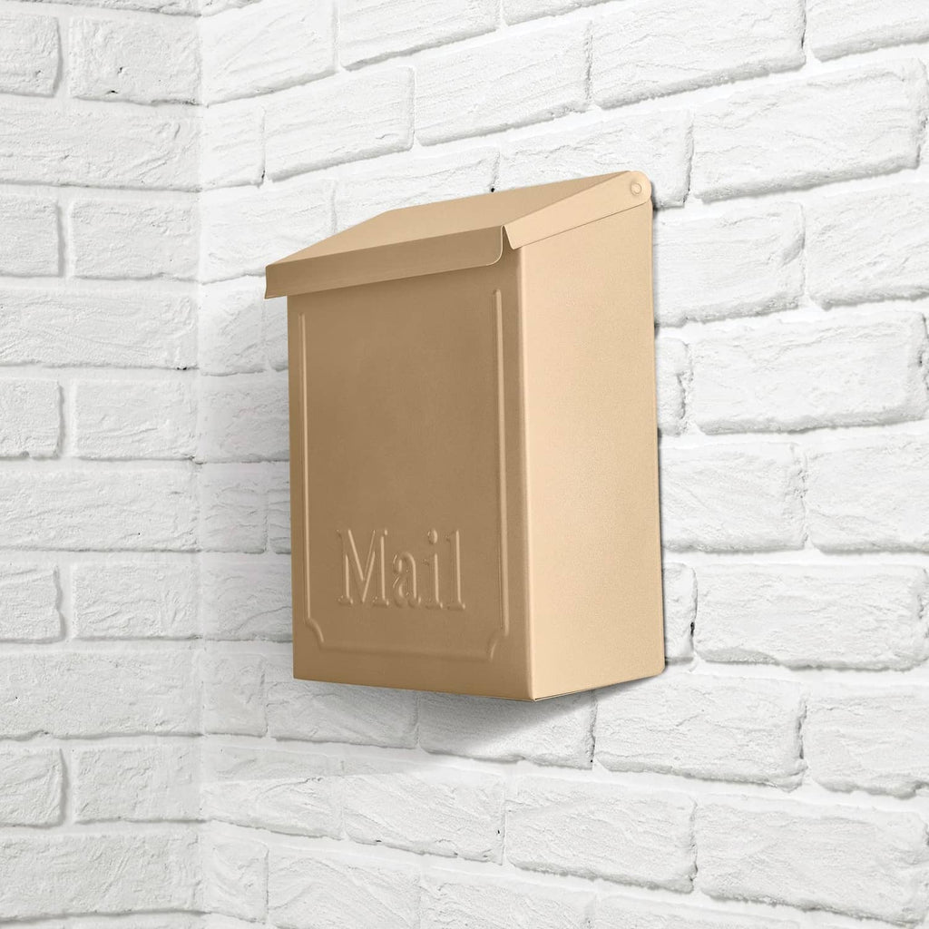 Metallic bronze mailbox with hinged lid on brick wall