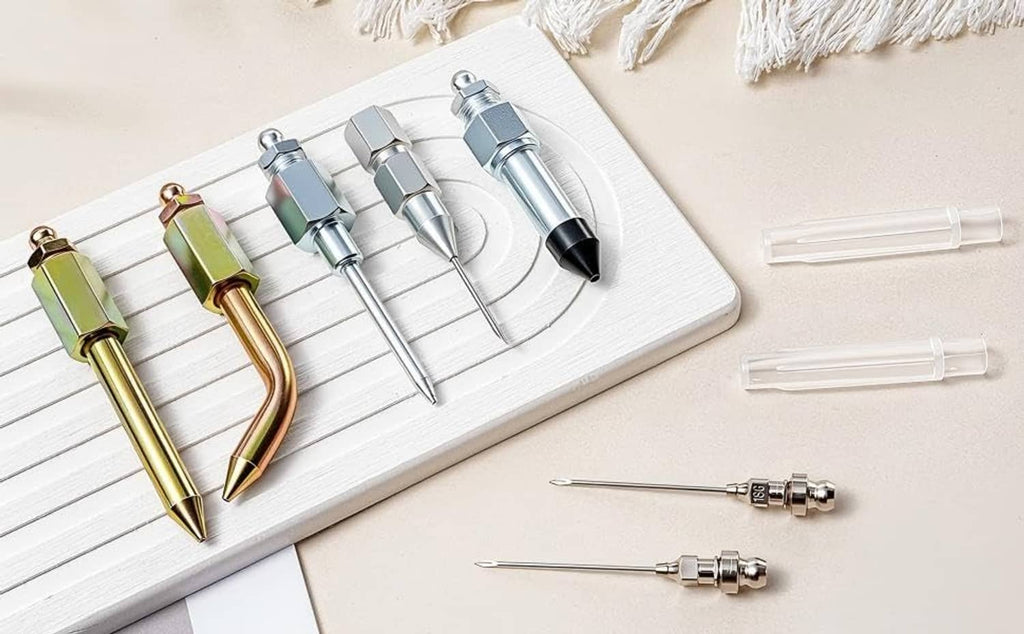 Grease gun needle tip kit on a tray with silver connectors and gold dispenser heads