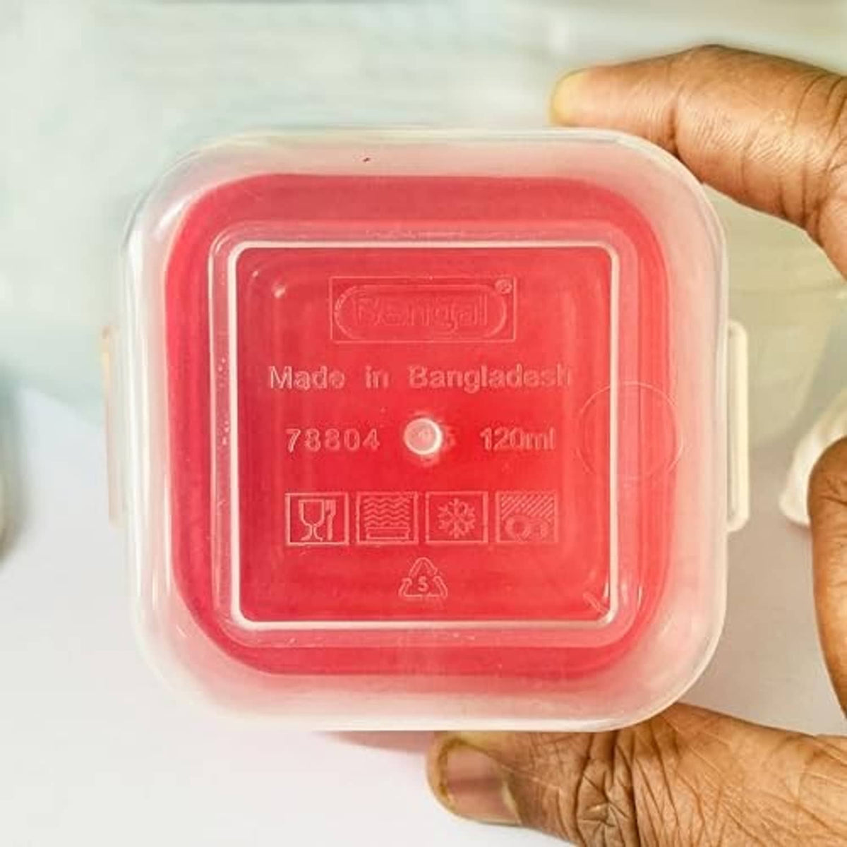 Small baby food container with red lid, clear body, embossed markings on lid