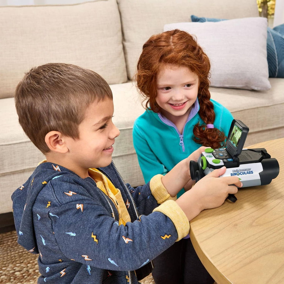 Two children holding LeapFrog-style binoculars, screen visible on device