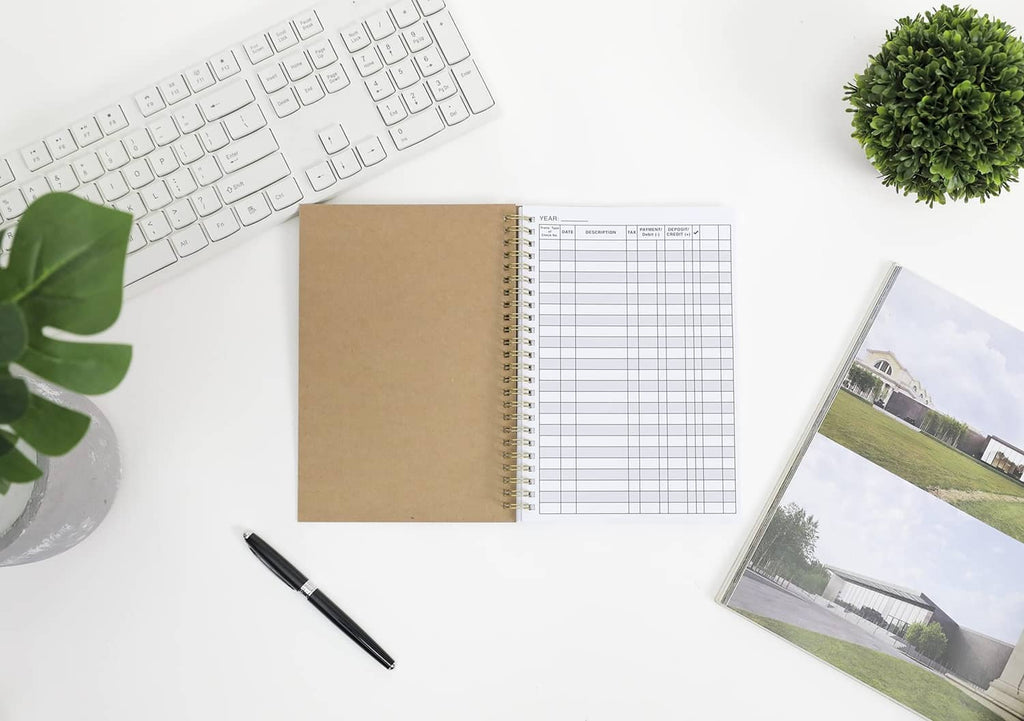Open tan spiral-bound account tracker ledger showing blank grid rows and columns