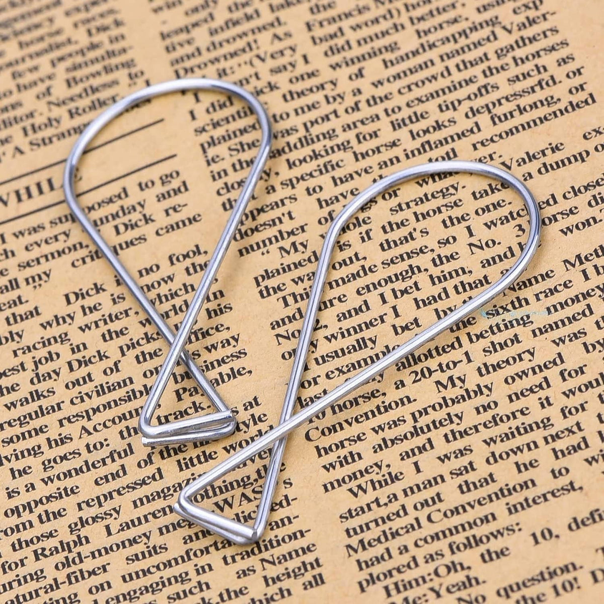 Two silver ceiling hook clips with triangular top and curved loop