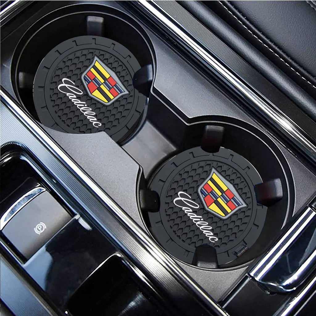 Black silicone cup holder coasters with Cadillac crest, angled view in console