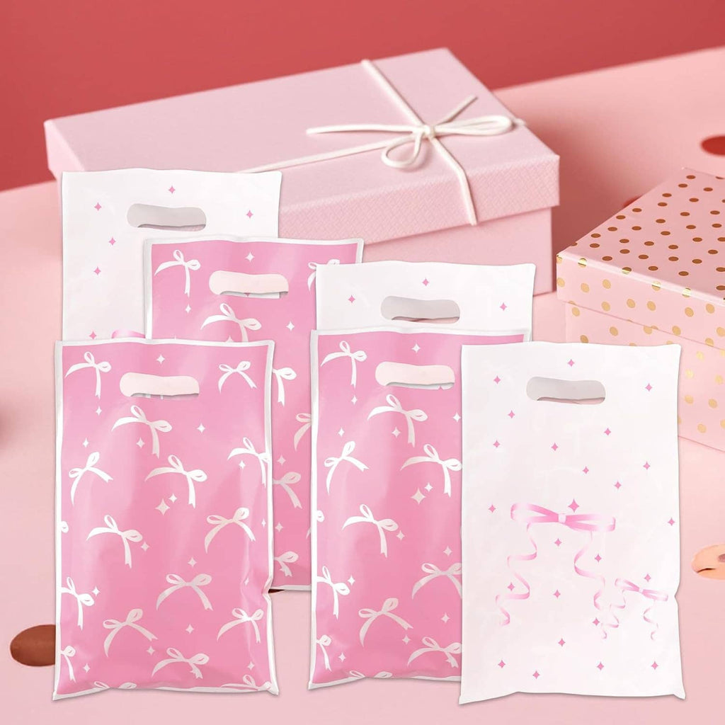 Stack of pink and white bow-pattern gift bags with cutout top handles
