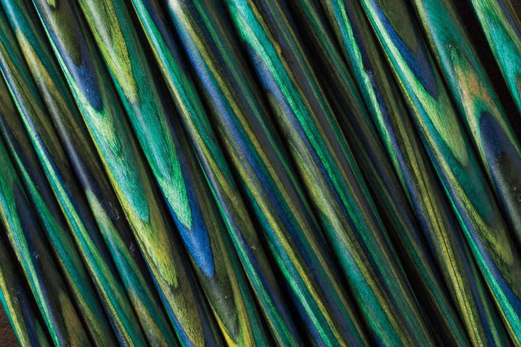 Close-up of green and blue mosaic wood knitting needle shafts