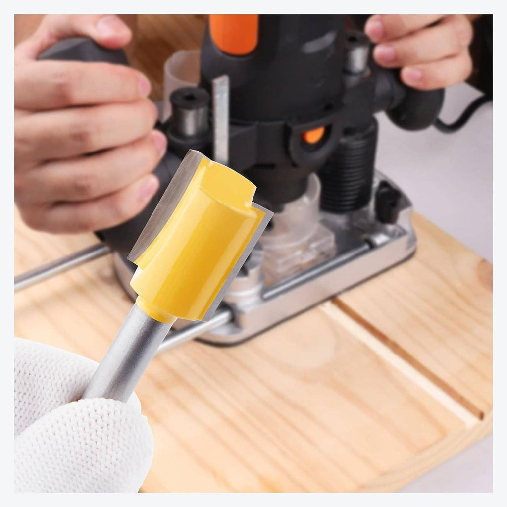 Router bit in use: gloved hand guiding a yellow cutter on a wooden board