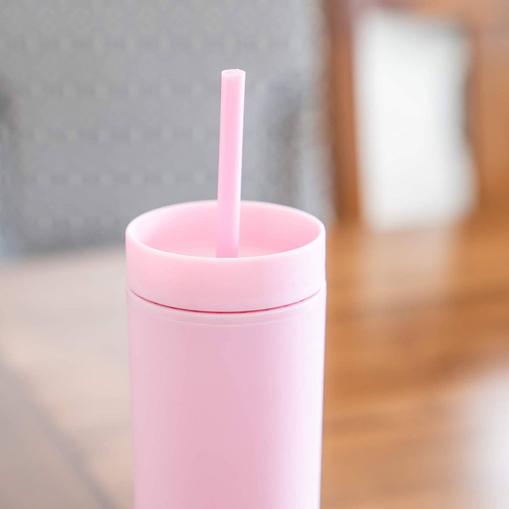 Pink skinny tumbler with lid and straight drinking straw, close-up