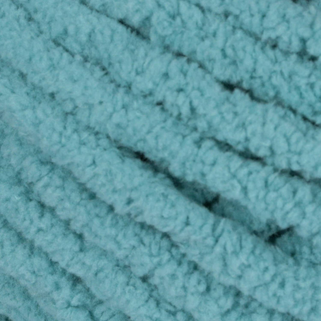 Close-up of light teal chenille yarn knit texture with thick loops
