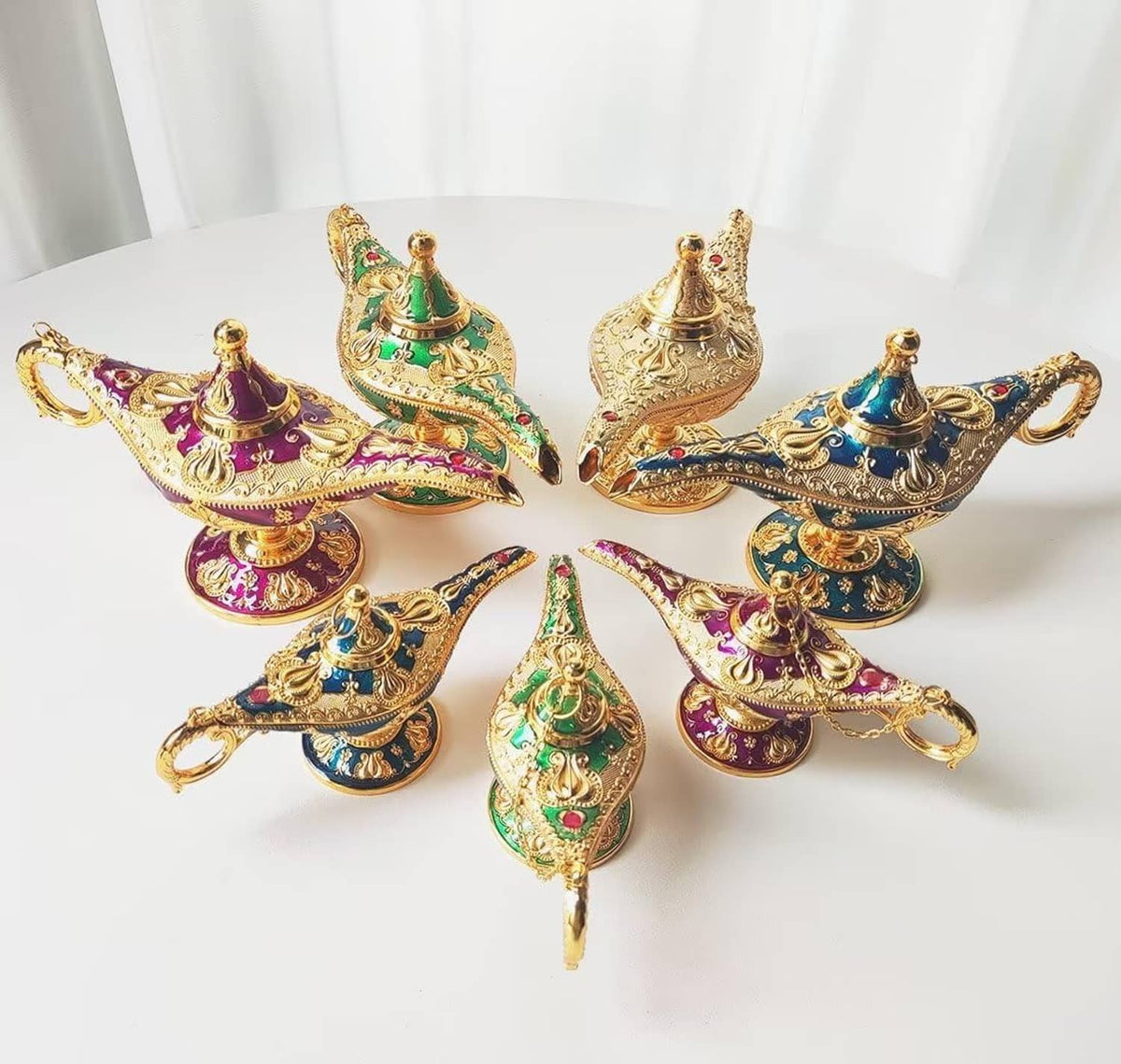 Set of ornate genie lamp props in purple, blue, green, and gold with gold handles