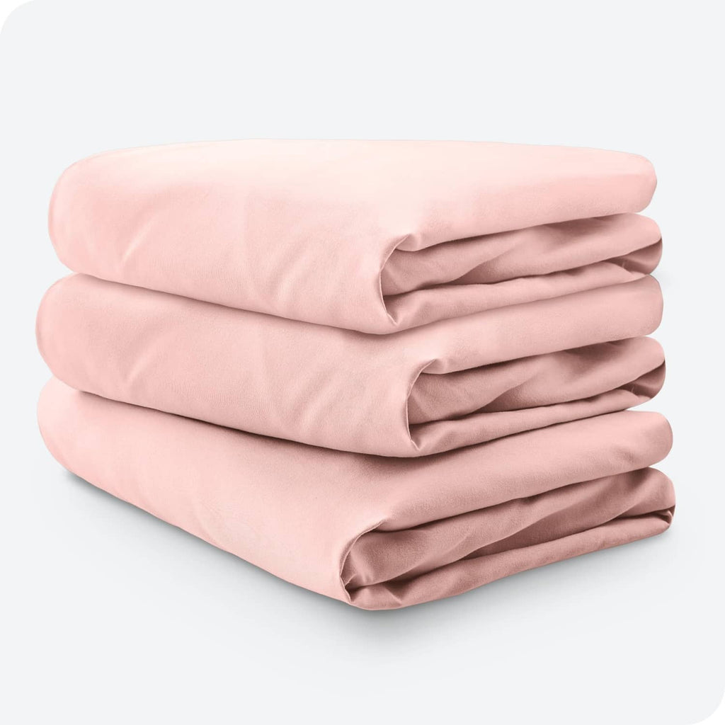 Stack of pink crib fitted sheets, folded set with smooth microfiber fabric finish