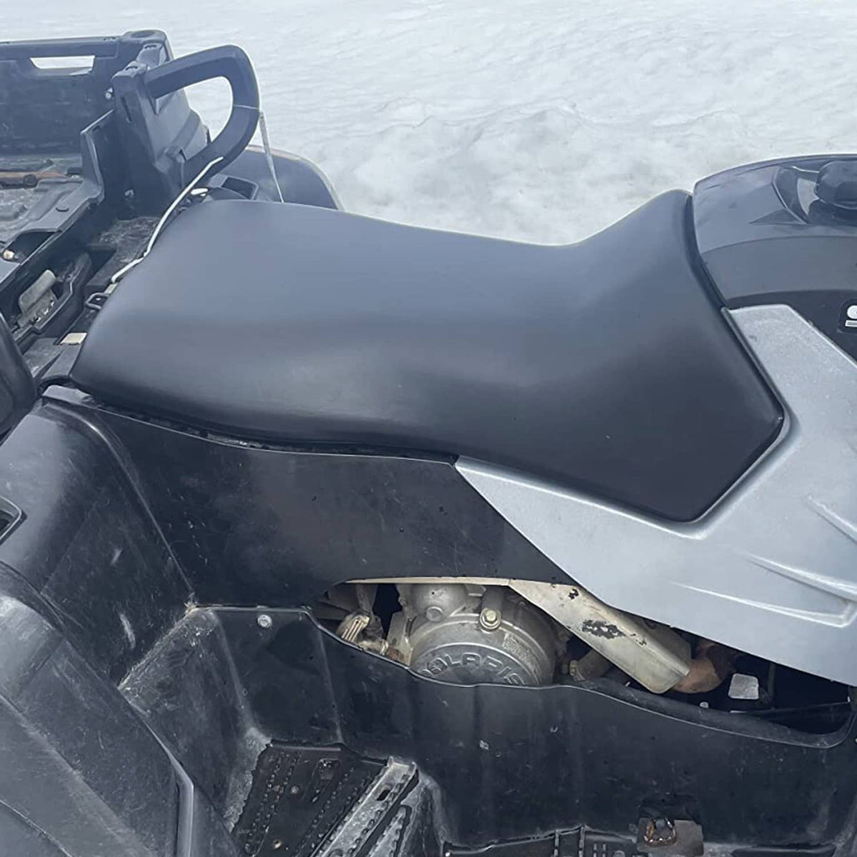 Black ATV seat with integrated side panels, viewed from the rear and side