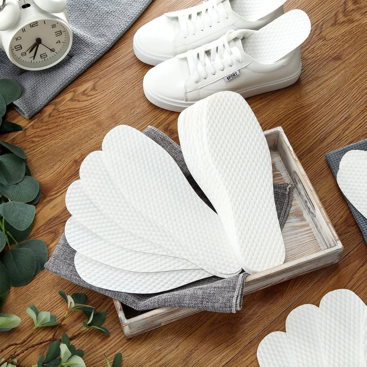 Disposable white shoe liners on box insert, textured non-slip insole covers.