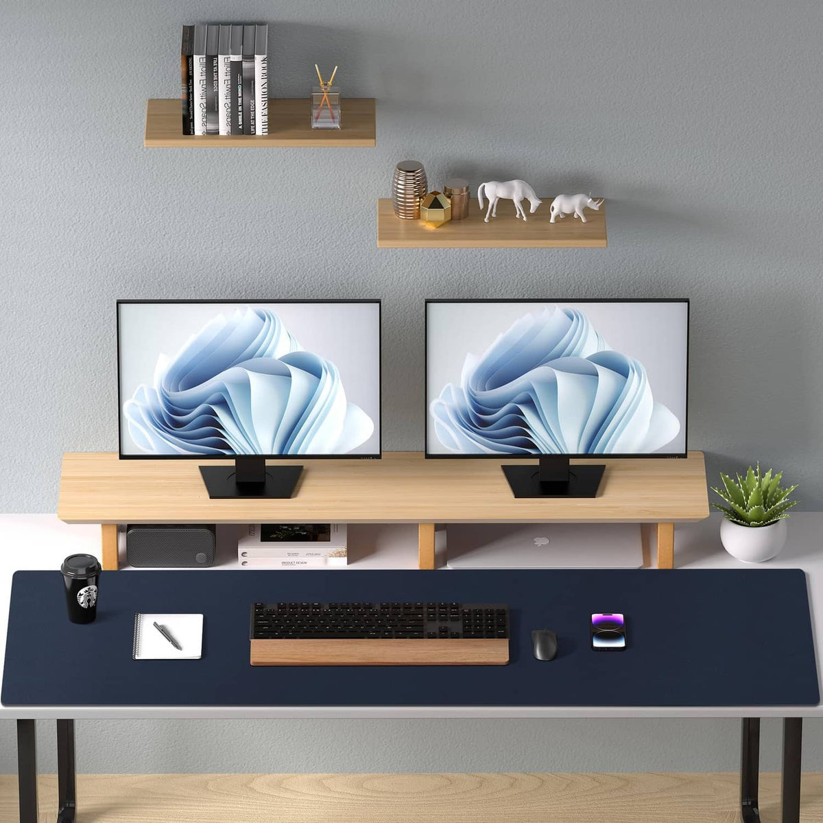 Dark blue desk pad protector covering a desk with laptop keyboards and office items.