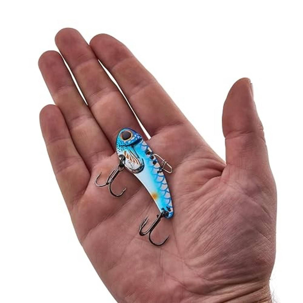Hand holding blue-silver blade bait lure with two treble hooks