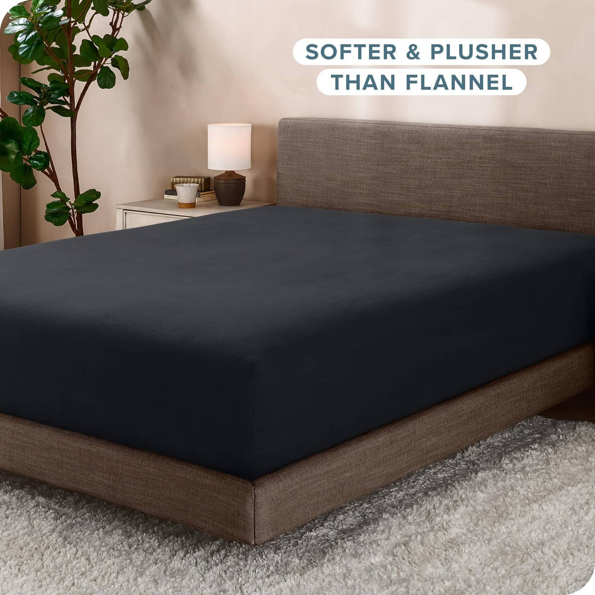 Black fitted fleece sheet on bed with smooth top and elastic skirt