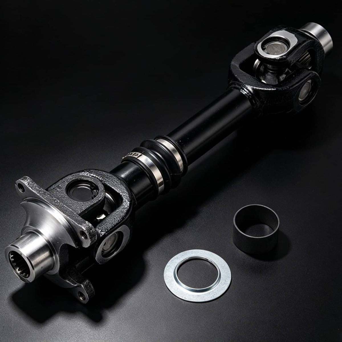 Rear propeller shaft with metal yokes, black center section, and washers