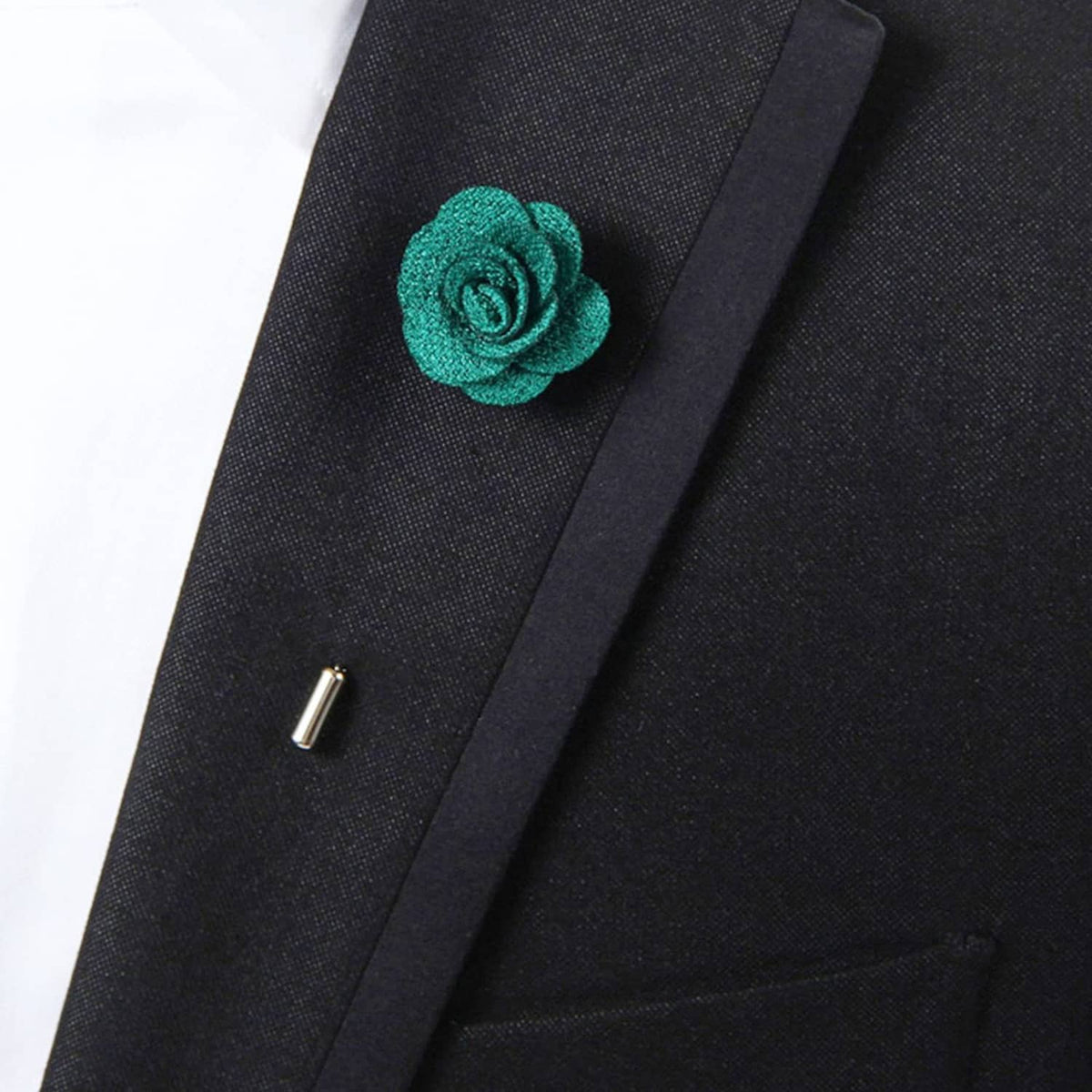 Teal fabric rose lapel pin on dark suit lapel, close-up