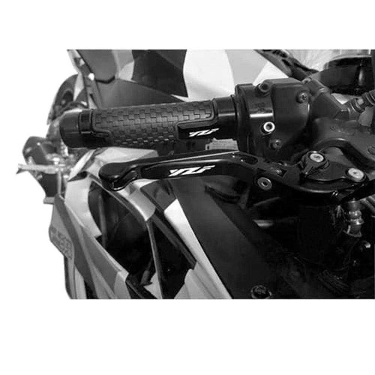 Black motorcycle brake and clutch lever installed near handlebar, close-up