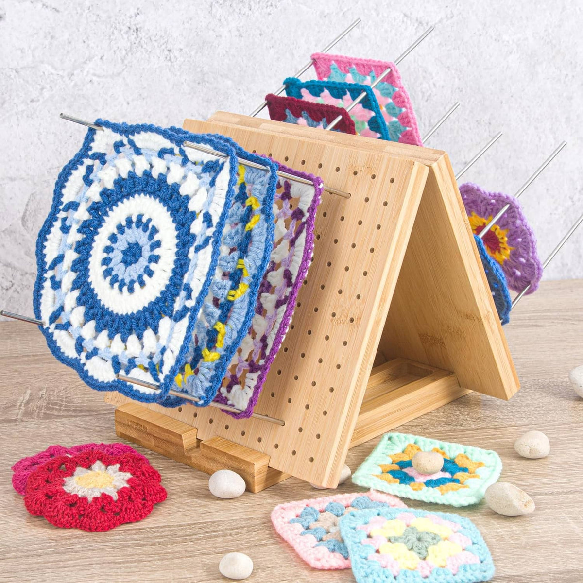 Crochet blocking board with peg pins holding crocheted motifs on the frame