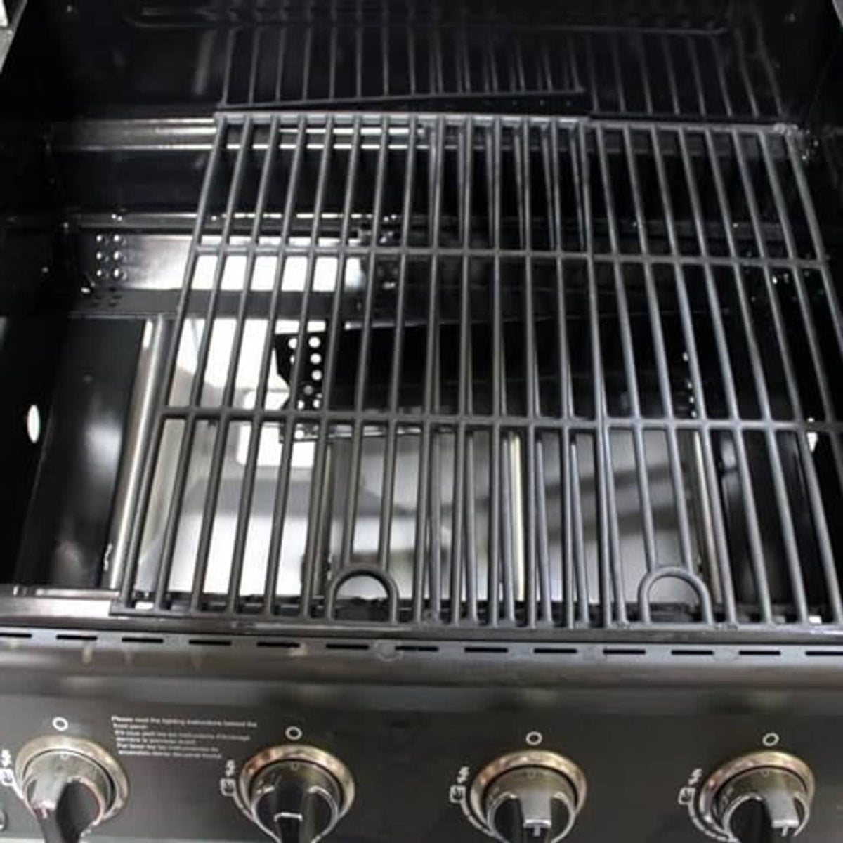 Black cast-iron cooking grate installed inside the grill firebox