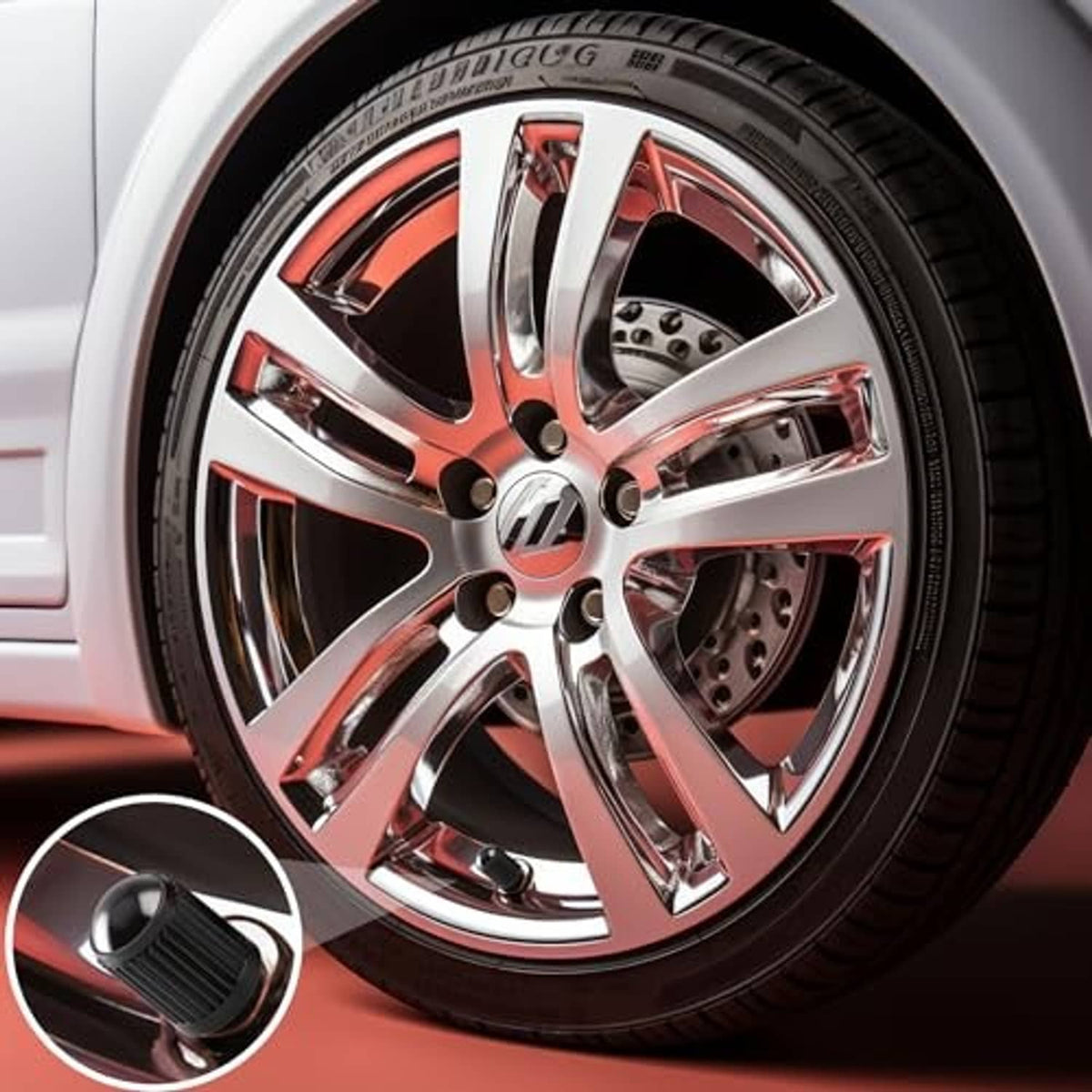 Black ribbed valve stem cap with red O-ring insert shown near a car wheel