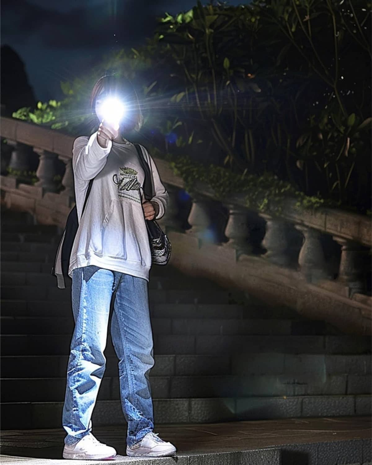 Handheld rechargeable flashlight casting bright white beam at night