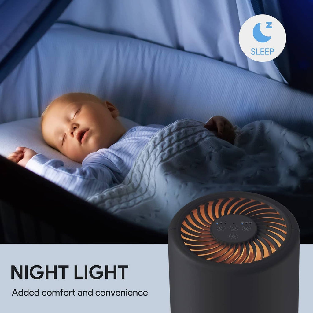 Black air purifier cylinder with warm night light glow on the top fan