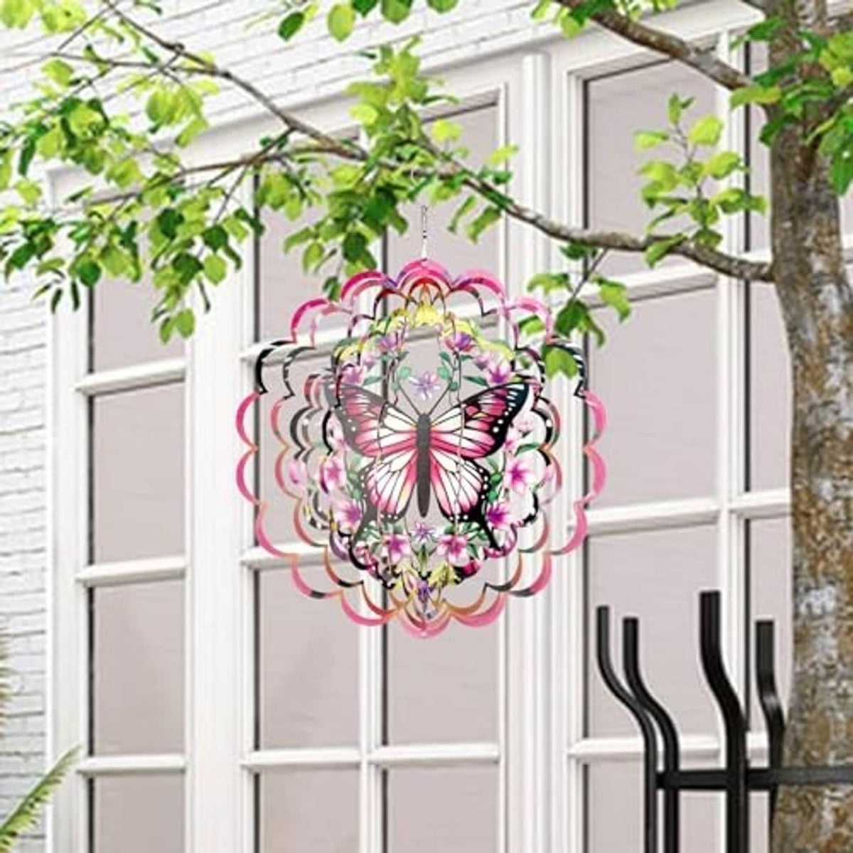 Hanging butterfly wind spinner with pink, purple, and green floral details, layered circular design.