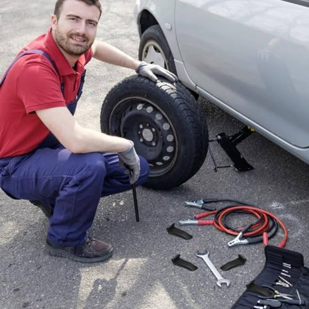 Black jaw clamp covers on tire changer tools near a vehicle wheel and loose tools.
