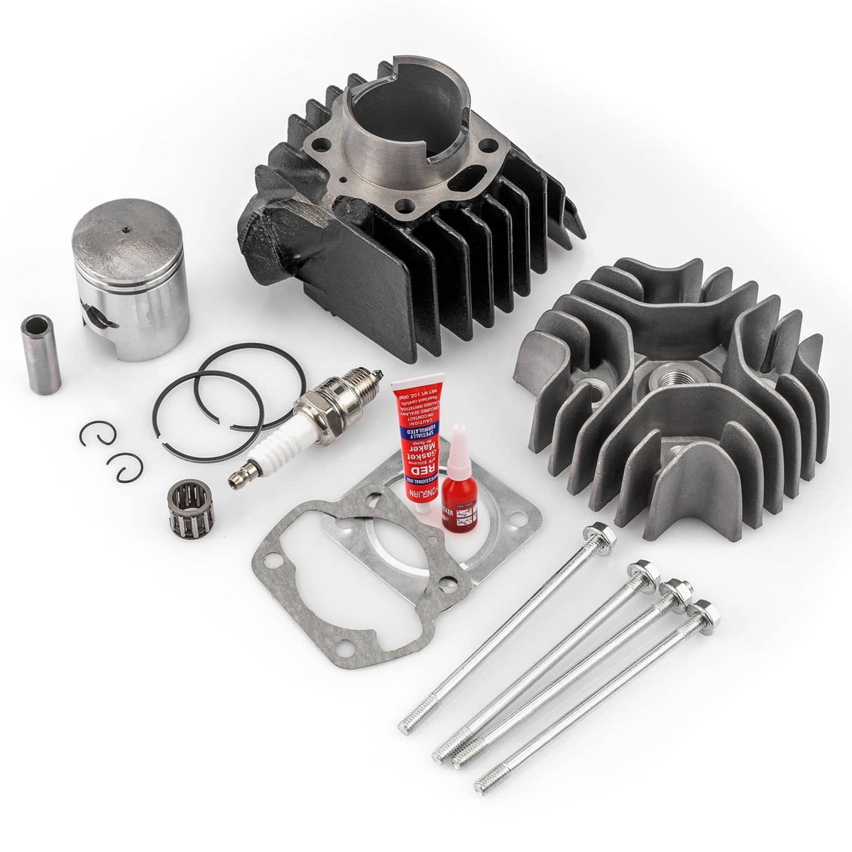 Cylinder and piston rebuild kit laid out: cylinder, piston, rings, gaskets, and pins