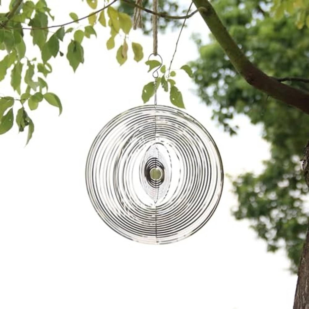 Silver round wind spinner hanging from a branch with concentric metal rings