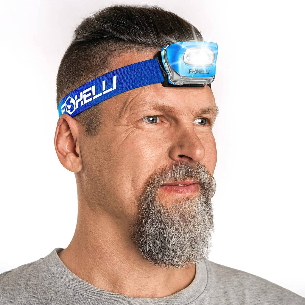 Blue headlamp with adjustable strap worn on an adult’s forehead, white LED on