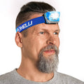 Blue headlamp with adjustable strap worn on an adult’s forehead, white LED on
