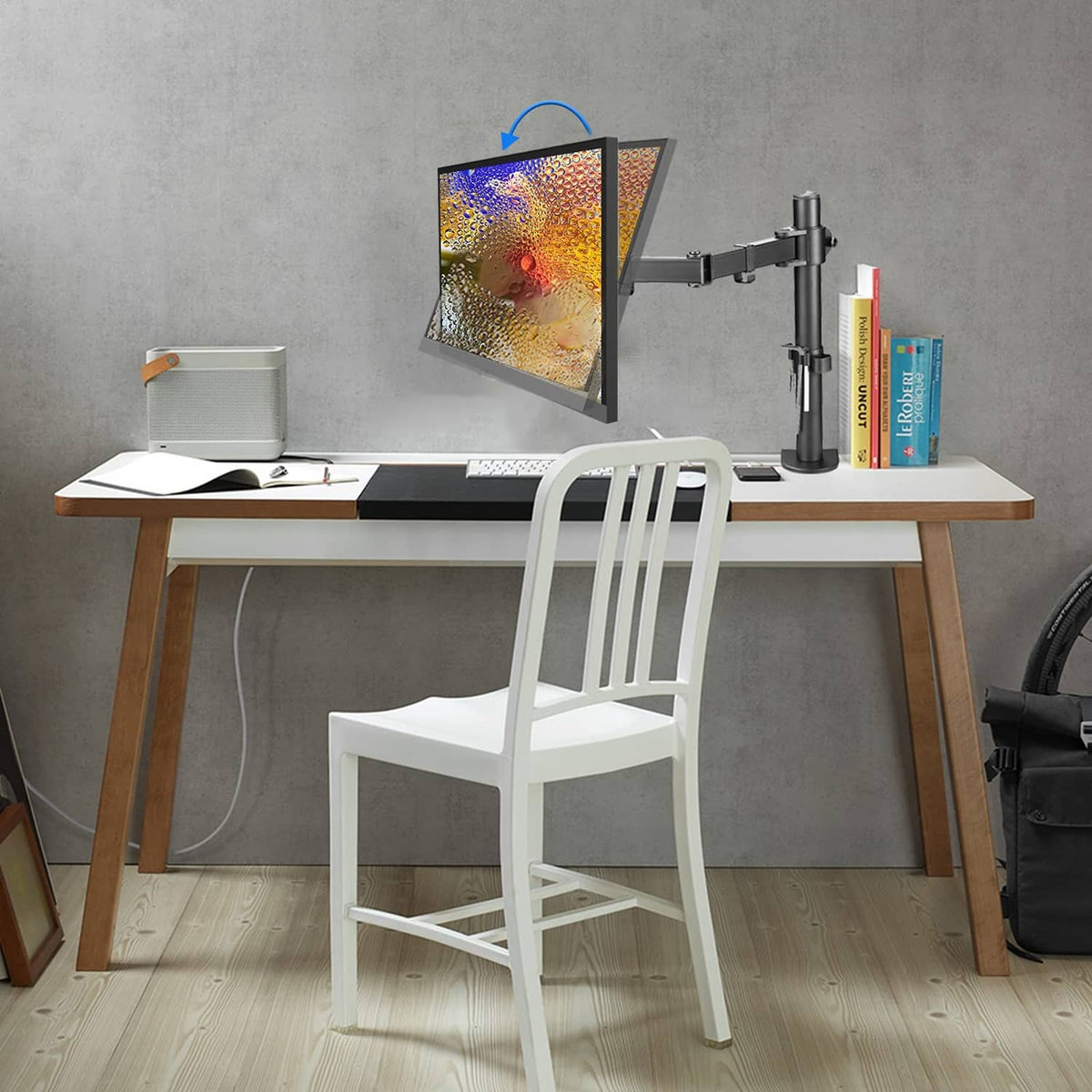 Single monitor arm on desk with swivel joint supporting a flat-screen monitor