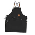 Black chef apron with cross-back straps, front pocket, and metal snap details