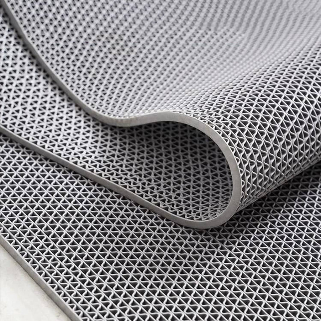 Dark gray PVC non-slip mat corner with rounded edge and lattice texture