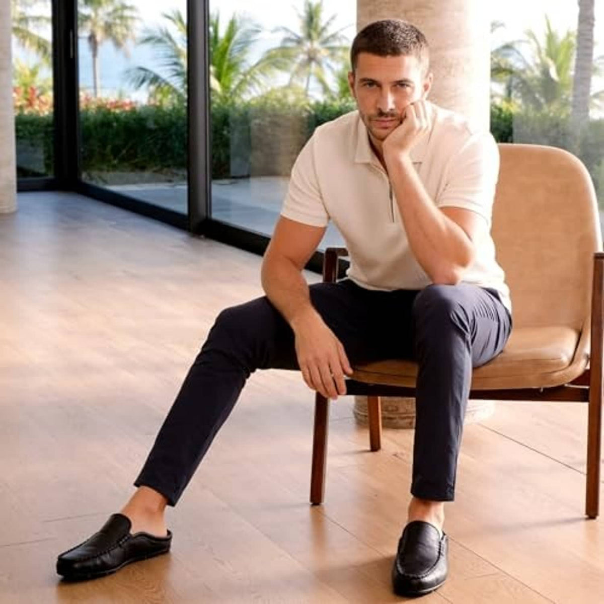Black leather slip-on mule clogs on feet, rounded toe and thick low sole