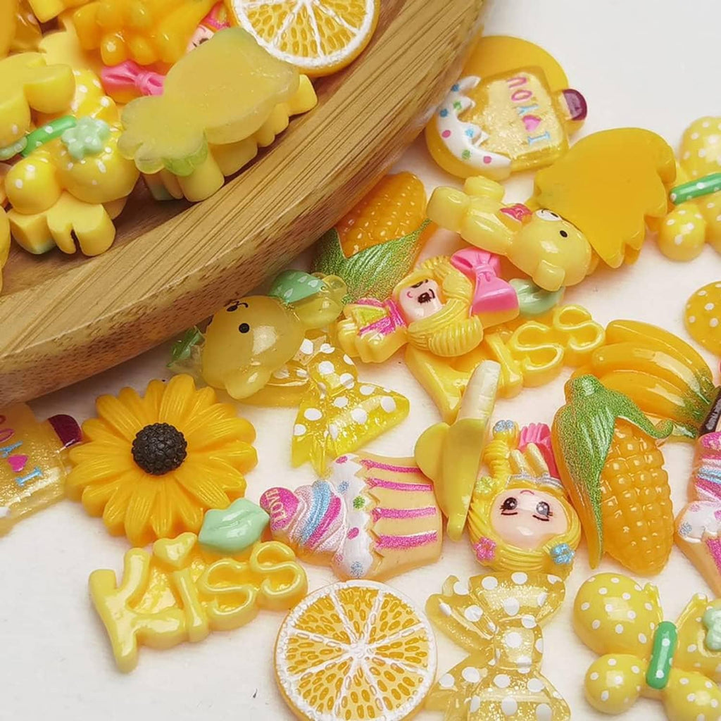Yellow flatback resin buttons in fruit and animal shapes, on a wooden scoop