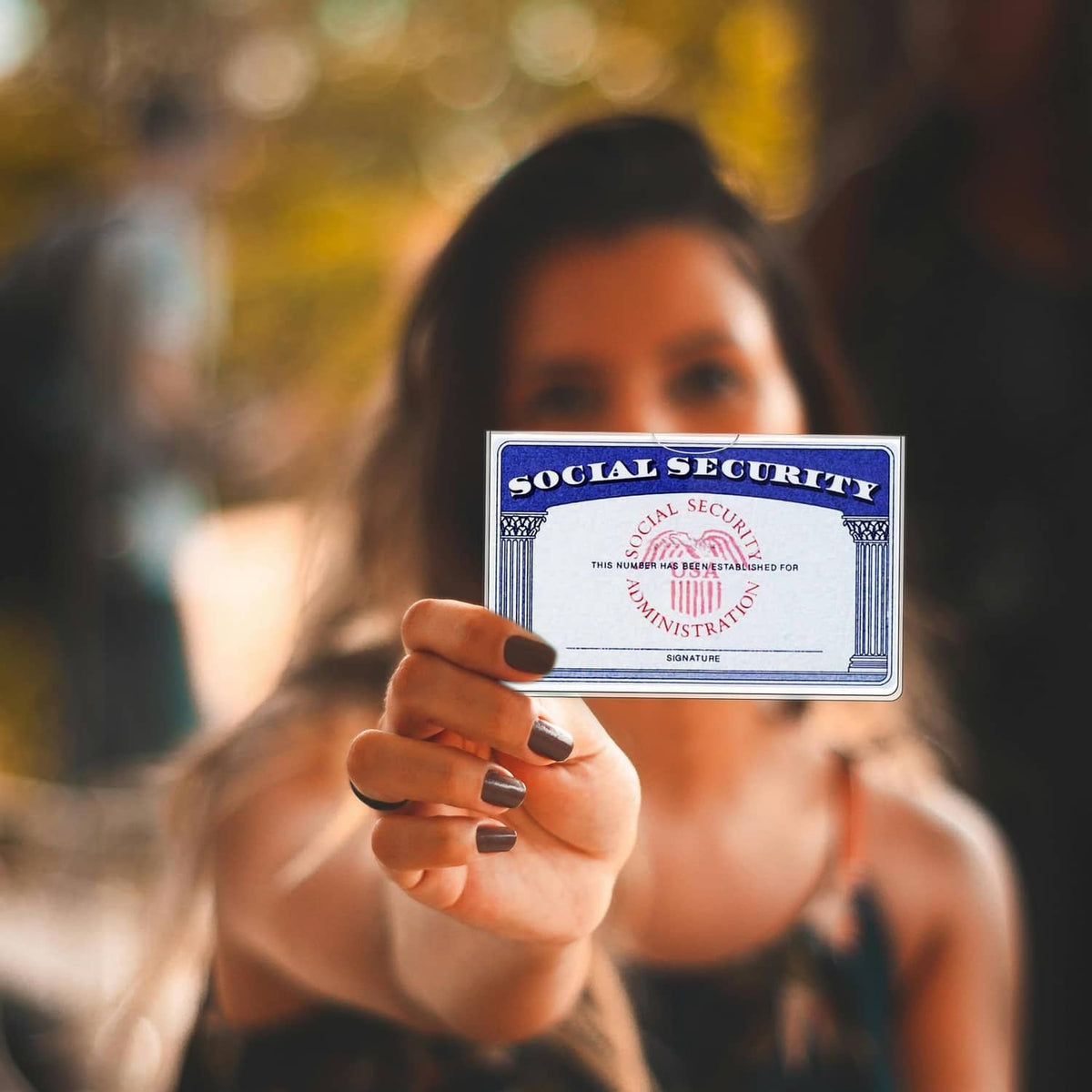 Clear protector with Social Security card held in a person’s hand