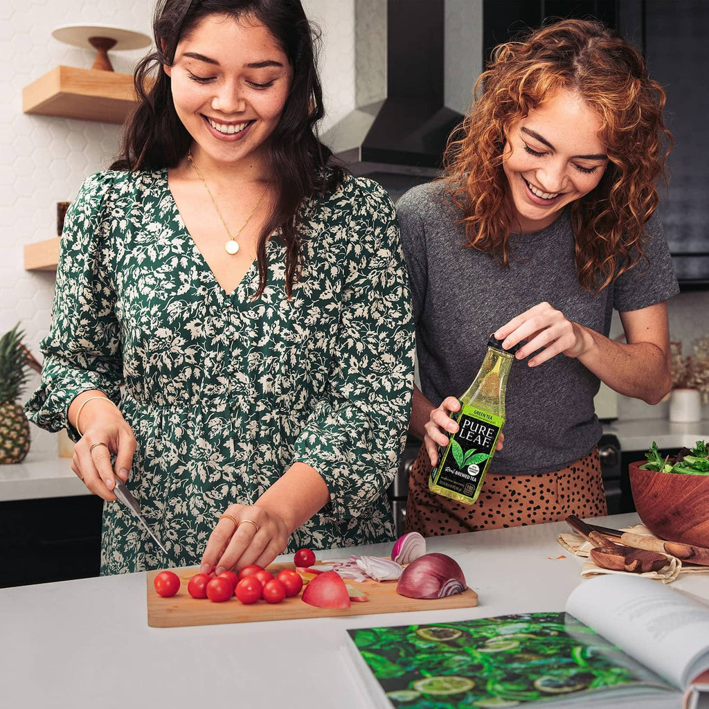 Pure Leaf unsweetened iced tea bottle held by a person at the kitchen table